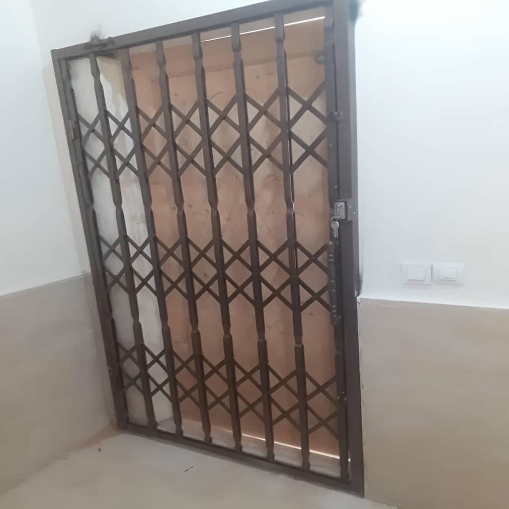 حفاظ درب آکاردئونی قهوه ای کنار چارچوب مرطوب