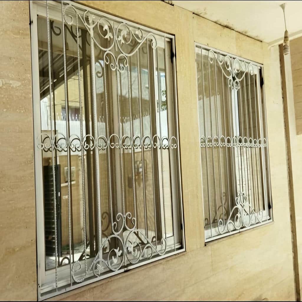 حفاظ پنجره فلزی با پوشش تیره و خطوط عمودی حفاظ پنجره فلزی با پوشش تیره و خطوط عمودی