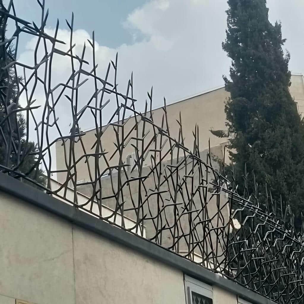 محافظ آهنی روی تاج سیمانی کنار ورودی ساختمان